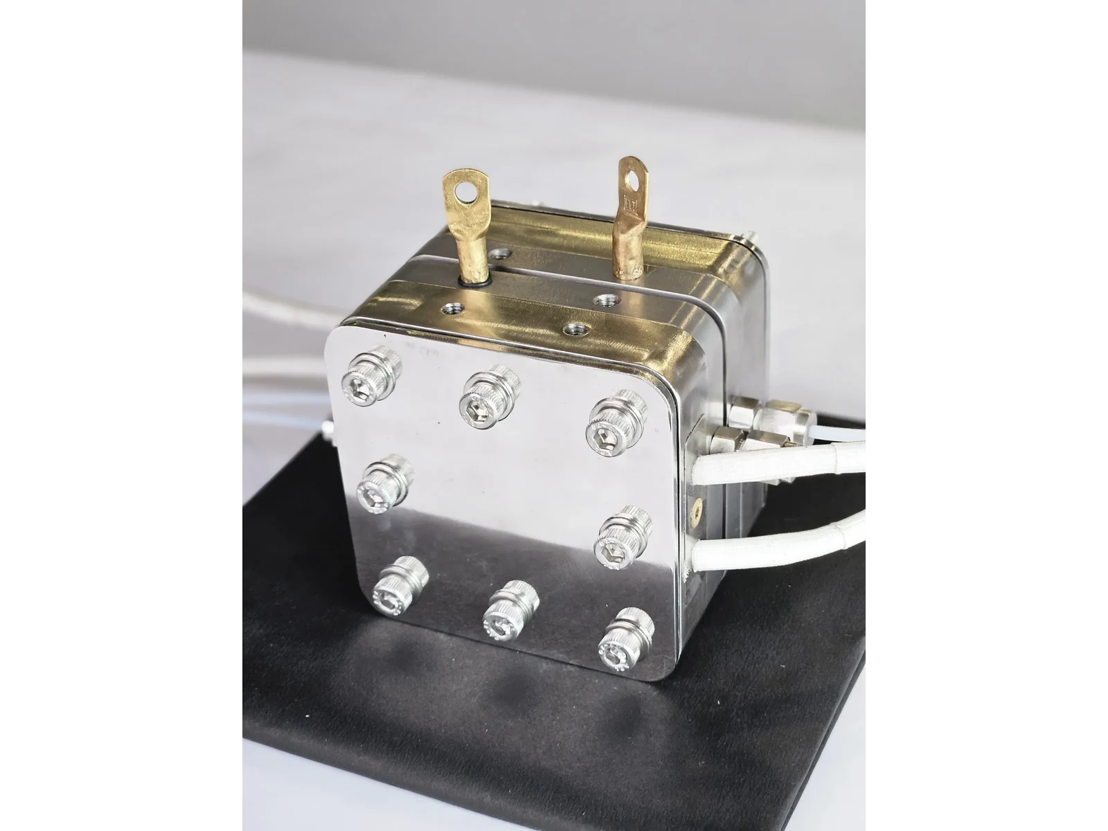 High Temperature PEM/AEM Electrolyzer Hardware - three-quarter view from the right showing the cell body and its outlet fittings