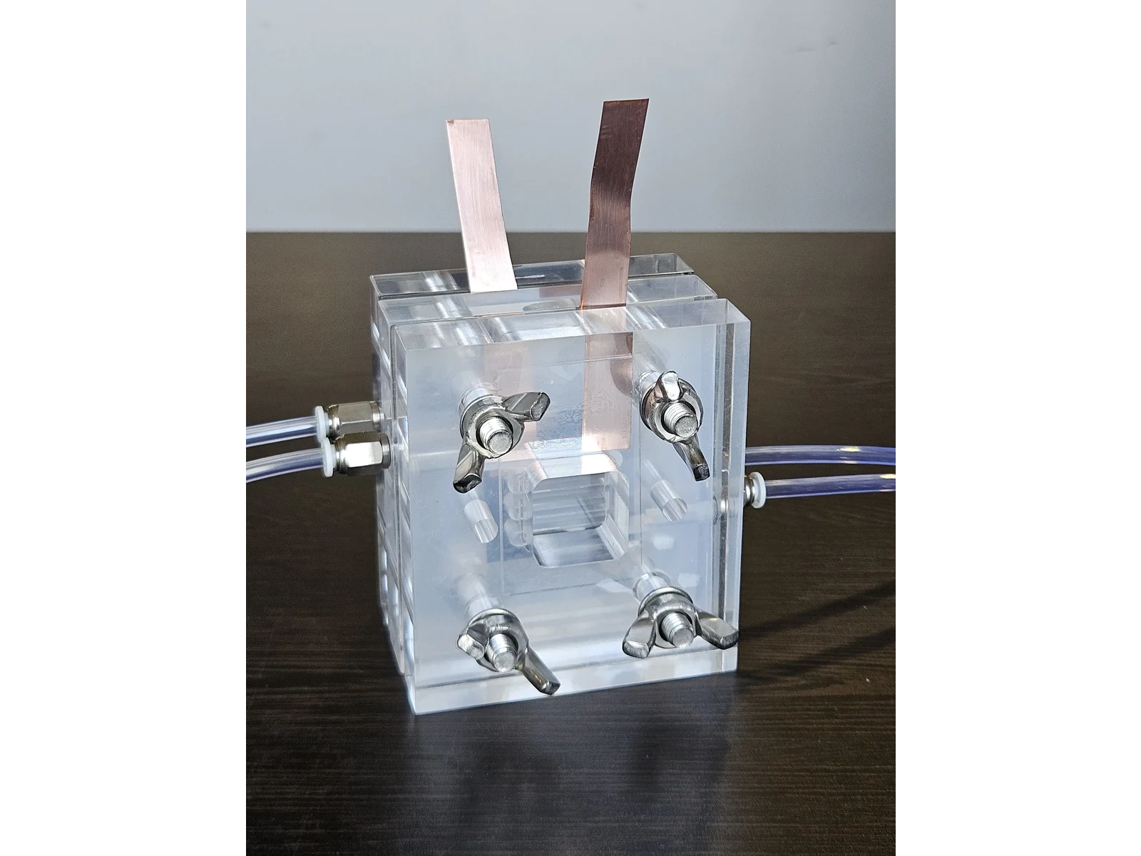 Vanadium Flow Cell Reactor - front view of the assembled cell with both copper current tabs and the electrolyte lines connected on either side