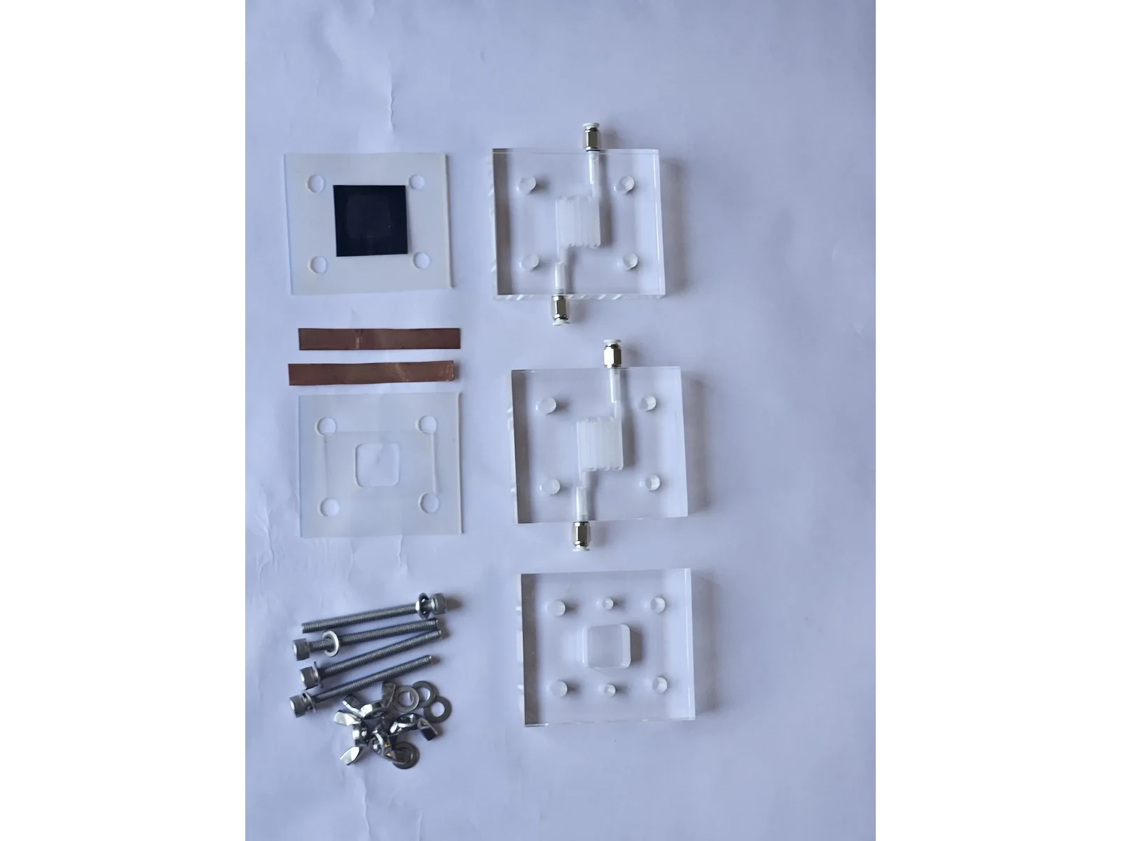 Vanadium Flow Cell Reactor - the cell dismantled into its end plates, gaskets, copper current tabs and fasteners